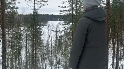 Nainen katselee maisemaa talvisessa metsässä