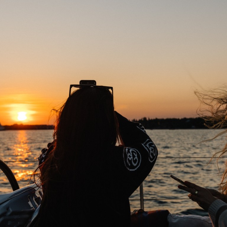Women capturing sunset from sailing boat