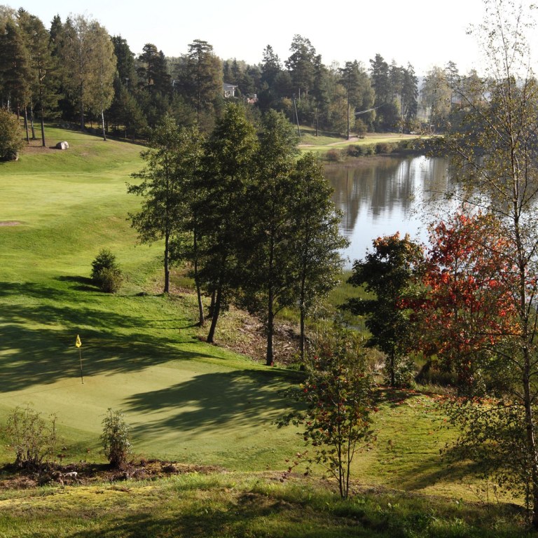 Yleiskuvaa Peuramaa golfin golfkentästä, näkyvillä väylää ja lampi.