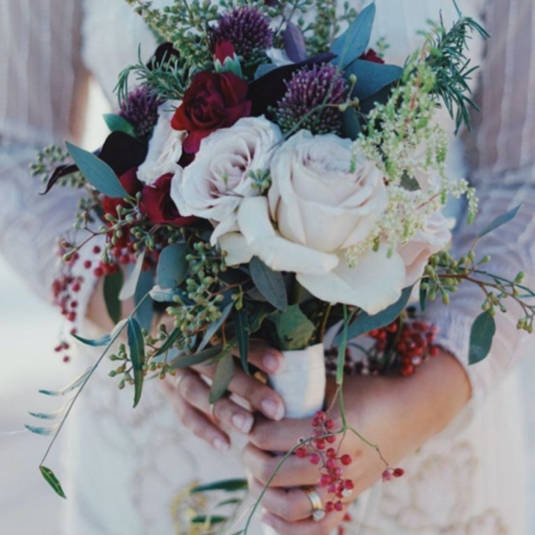 Bride in white dress holding a flower bucket