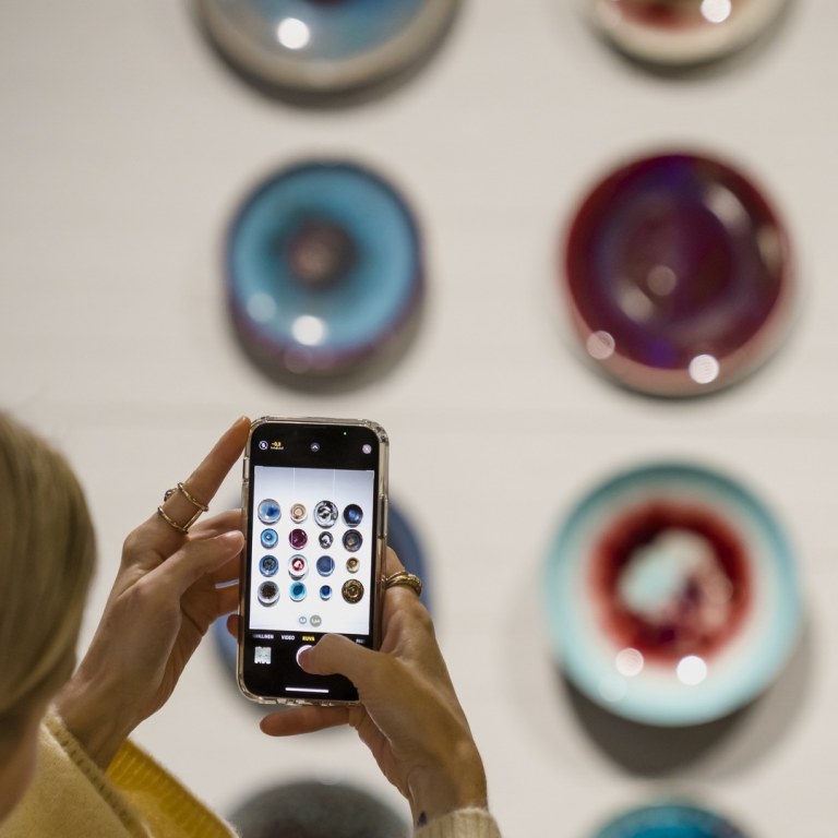 Naiset kuvaavat kännykällä taideteosseinää EMMA-museossa.
