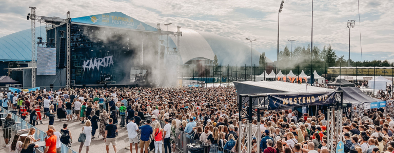 Tapiola festival with visitors and band in distance
