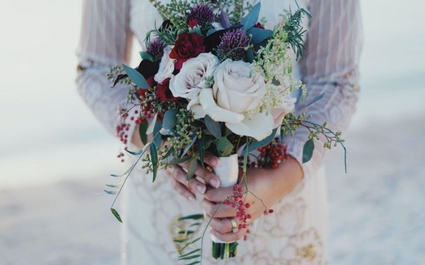 Bride in white dress holding a flower bucket