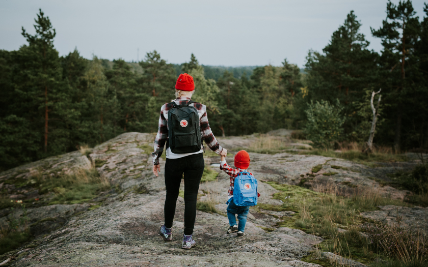 Woman with child walking on rock landscape in forest