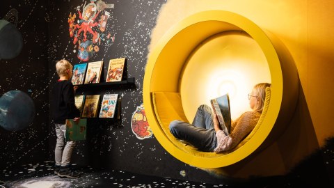 Children reading books in Mauri Kunnas Exhibition's space themed area.