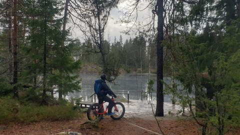 A fatbike rider admiring a frozen forest pond