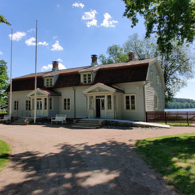 Wohls Gårdin kartanorakennuksen julkisivu. Rakennuksen takana näkyy Humaljärvi.