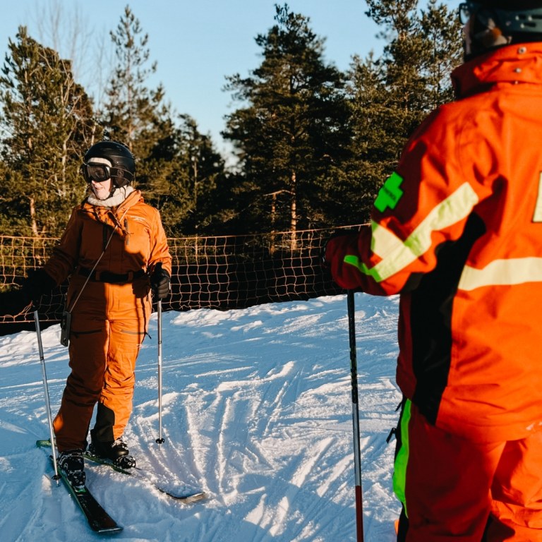 Woman skiing on slopes with instructor