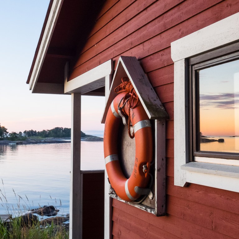 Red wooden house next to deck on Stora Herrö island