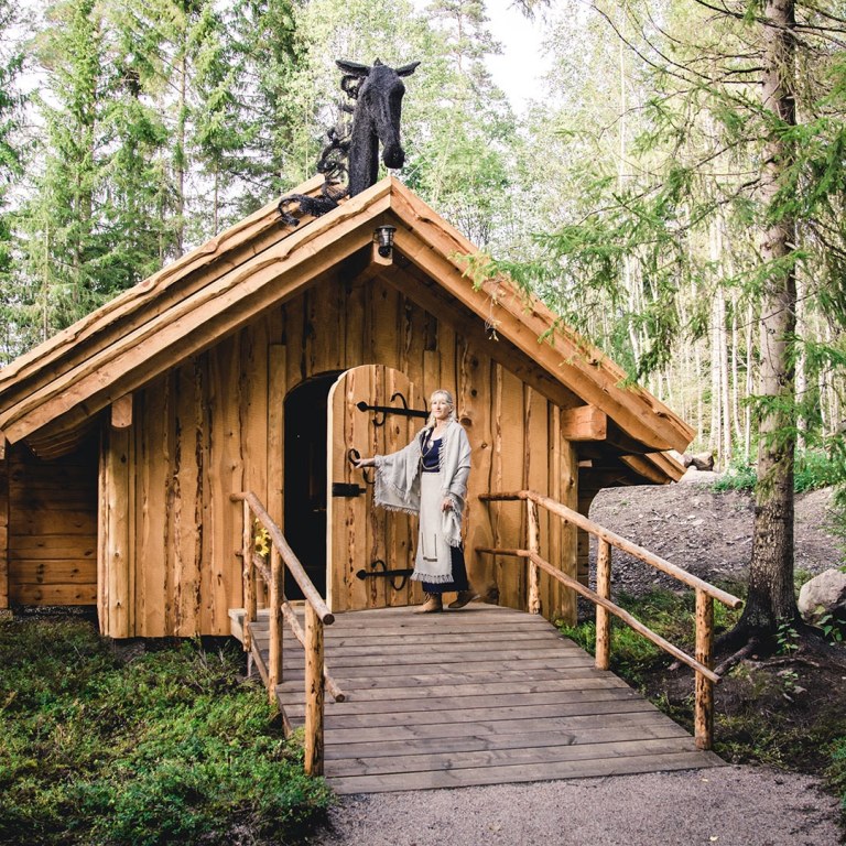 Woman in front of wooden cabin