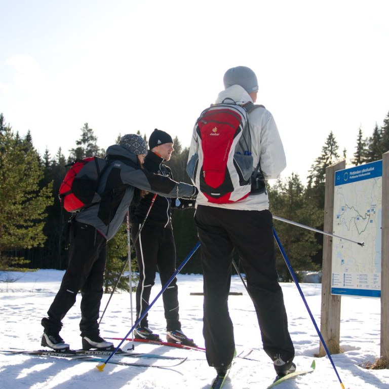 Group of cross-country skiers looking at map 