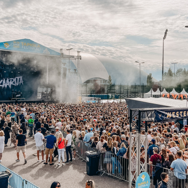 Tapiola festival with visitors and band in distance