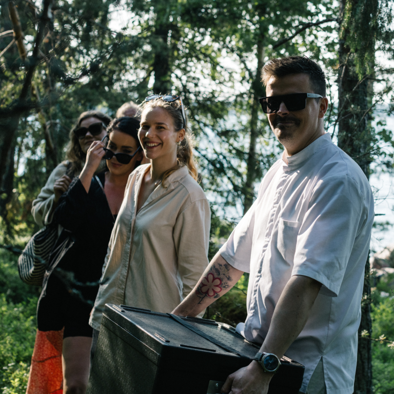 Group of people in forest during summer and with box of food