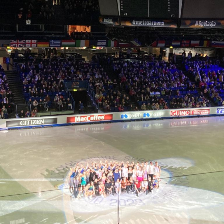 Group of Figure skaters posing on ice for photo in Espoo Metro Arena