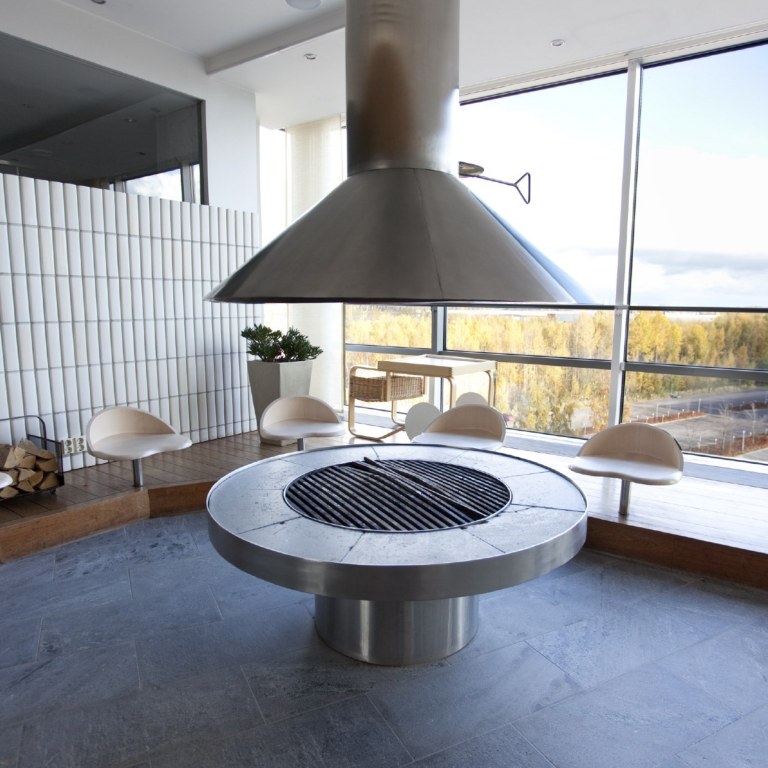 Round fire place inside a meeting room with a window view