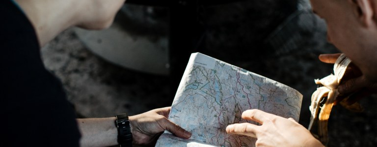Two persons planning trip with map