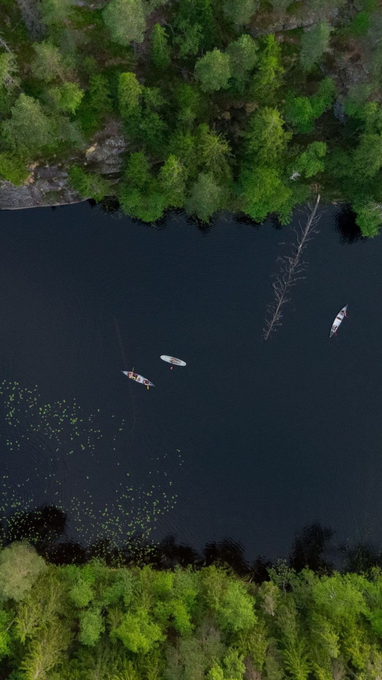 Drone photo of long lake in Nuuksio National Park and group Sup boarding