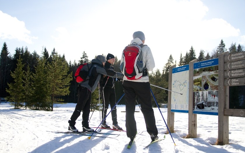 Group of cross-country skiers checking information board