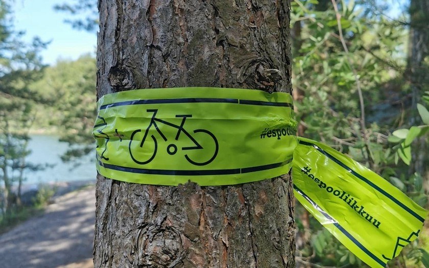 Vihreä opaste solmittuna puunrungon ympärille osoittamaan pyöräilijöiden omaa Saaristoreittiä.