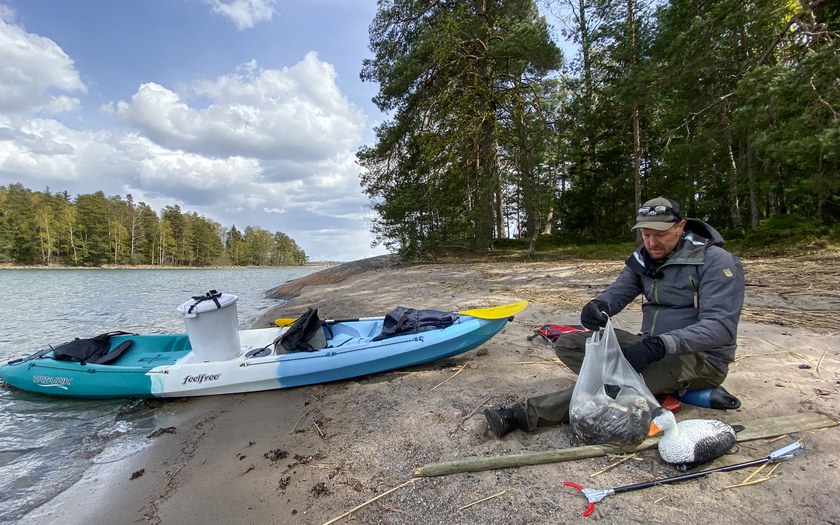 Peltsi saaristossa ploggaamassa roskia Itämerestä, istumassa rannalla kerättyjen roskien kanssa.