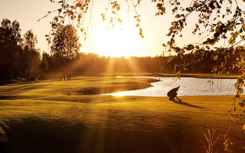 Ilta-auringossa kylpevä Hirsalan golfkenttä.