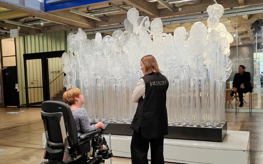 Wheelchair visitor with museum guide xploring exhibition