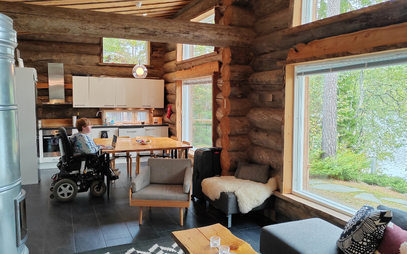 Wheelchair visitor inside log house by Hawkhill Cottage Resort