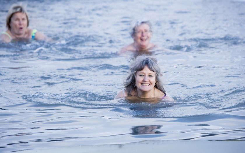 Kolme naista uimassa avannossa iloisin mielin.