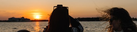 Woman photogprahing sunset on the boat