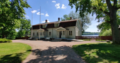 Wohls Gårdin kartanorakennuksen julkisivu. Rakennuksen takana näkyy Humaljärvi.