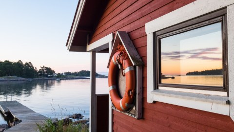 Red wooden house next to deck on Stora Herrö island