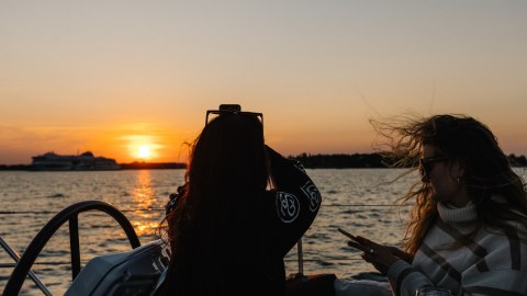 Women capturing sunset from sailing boat