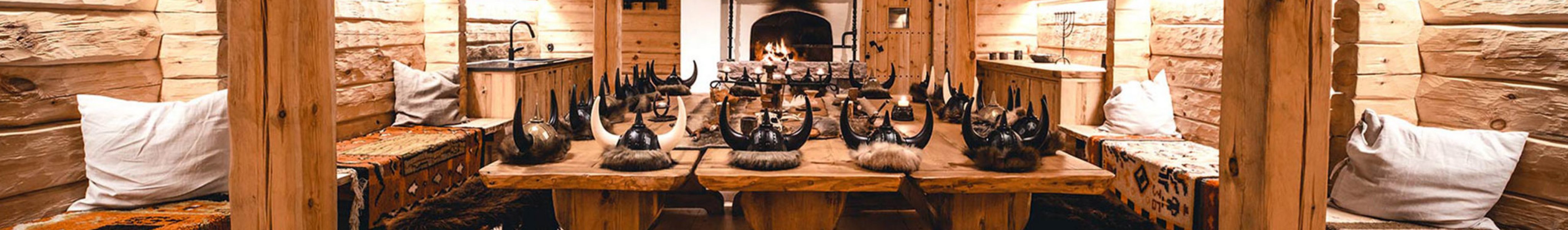 A long wooden dining table with viking hats on the table.