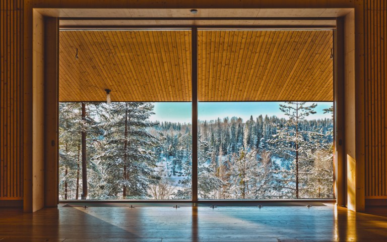 Suomen luontokeskus Haltian auditorion iso ikkuna, josta avautuu luminen metsämaisema.