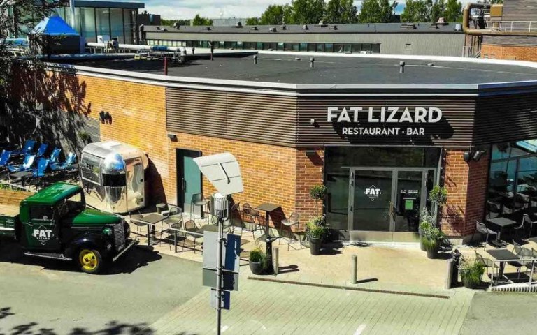Ravintola Fat Lizardin julkisivu ja terassi, jonka edustalla Fat Lizard logolla oleva lava-auto.